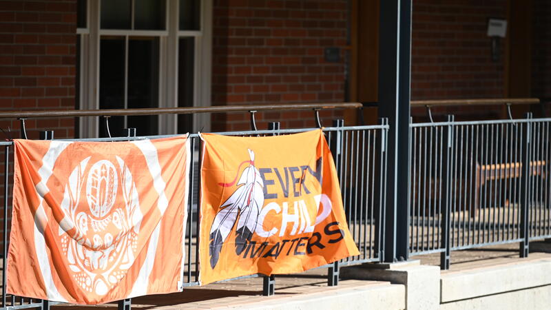 Two flags from Orange Shirt Day hang in on the rails of Crothall Building. 