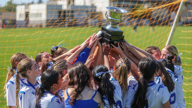 Senior Girls Soccer Team all hoist the ISAA Trophy together