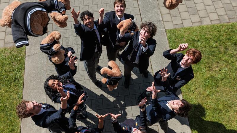 A group of 2025 graduate students toss their bears up in to the sky.