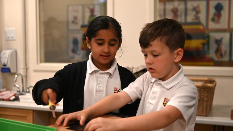 Grade 2 students work together in the iLab on a cardboard project.