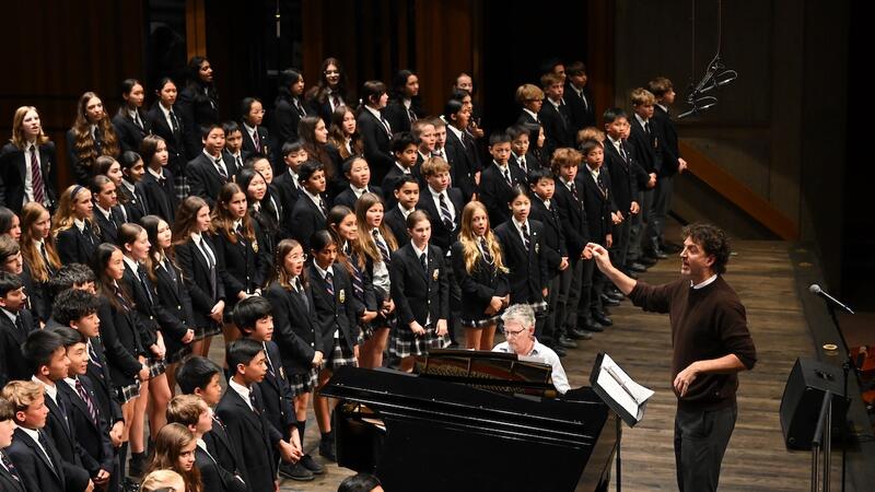 Middle School Choir takes to the stage with Duncan Frater conducting. 