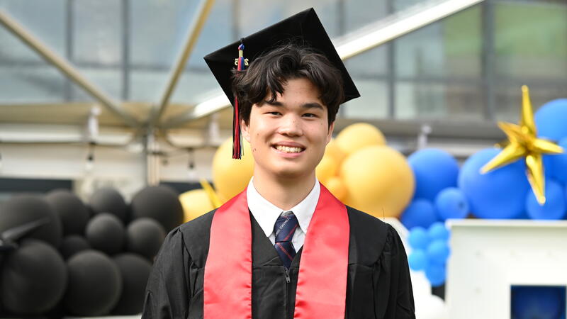 Valedictorian Jaden Berger-North poses in his regalia on graduation day.