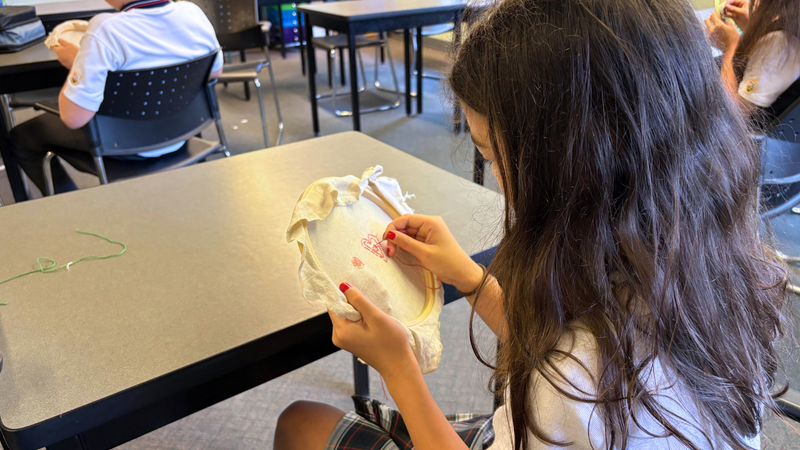 A student doing embroidery stitching