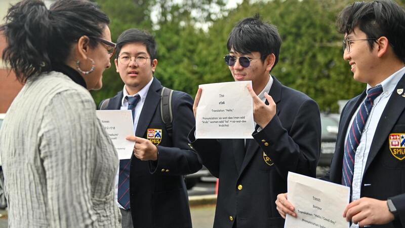Students hold greetings in different languages to celebrate multilingualism