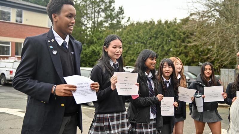 Students hold greetings in different languages to celebrate multilingualism