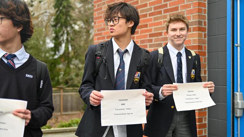 Students hold greetings in different languages to celebrate multilingualism