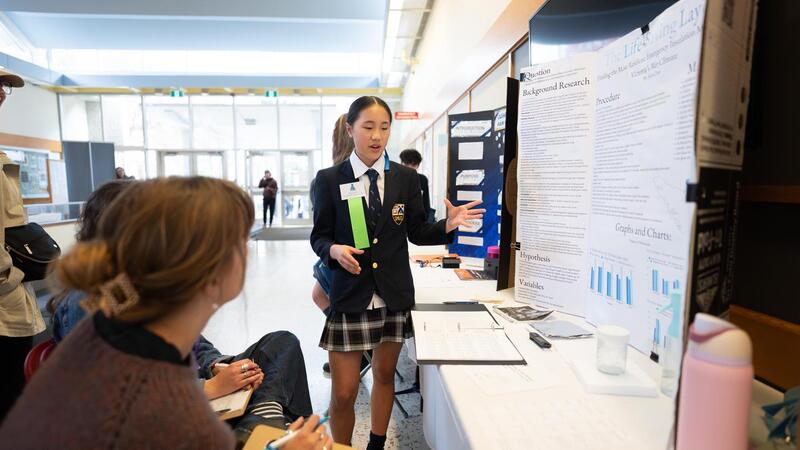 Kara Chen presents her science fair project to onlooking judges.