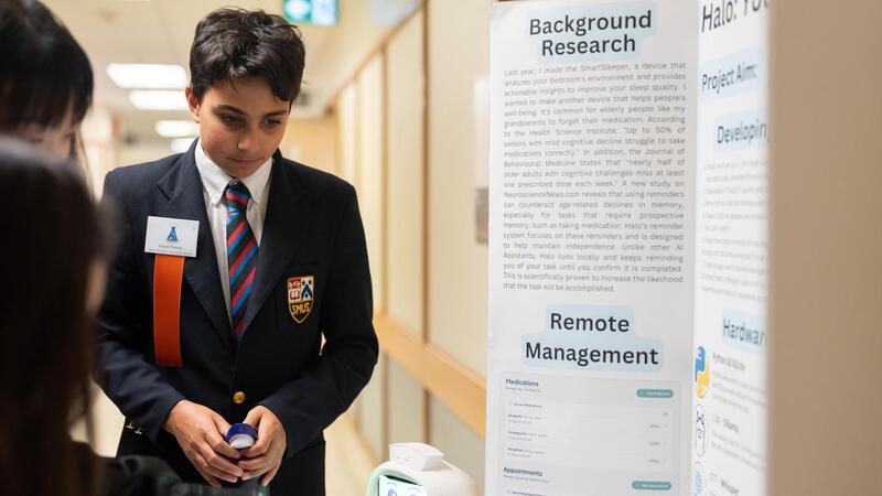 Grade 8 student Isaiah Pereira watches as an observer looks at his science fair project