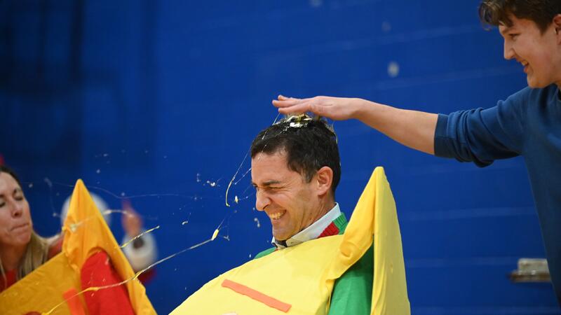 Eliot Anderson gets an egg cracked on his head at a Christmas assembly