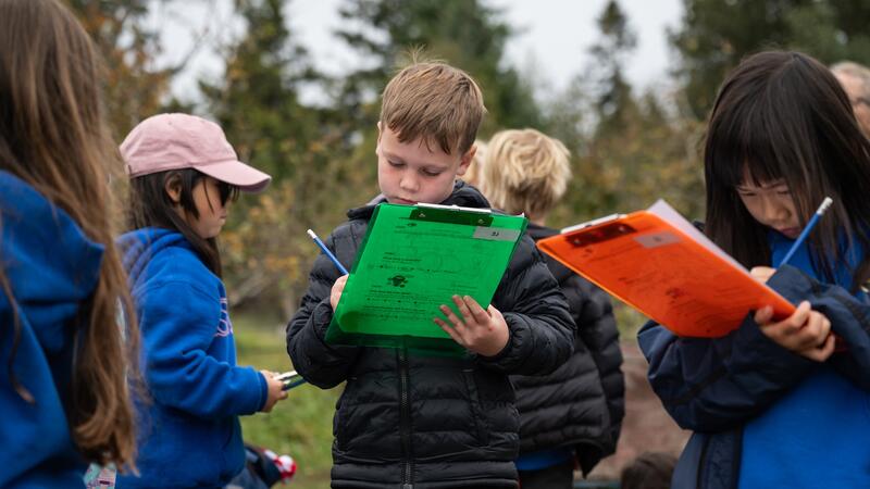 Students write observations on clip boards.
