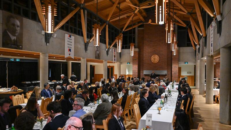 A full room of dinner attendees fill long tables in Graves Hall