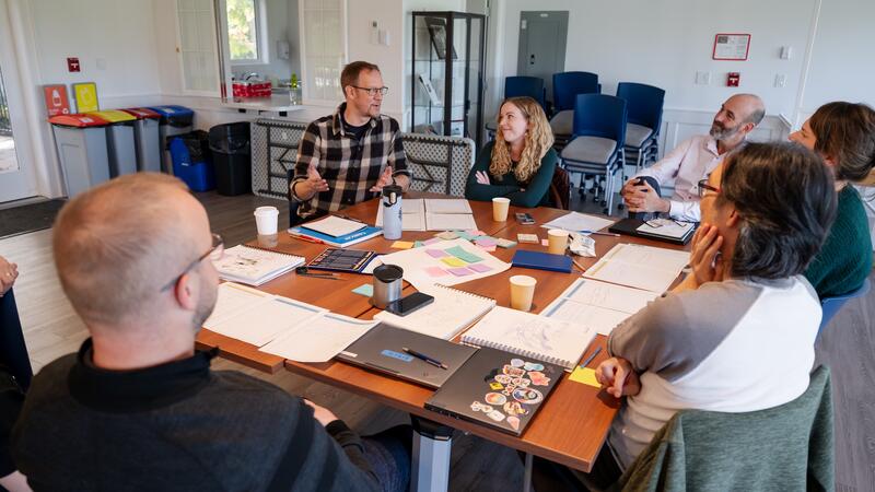 Staff talk around a table